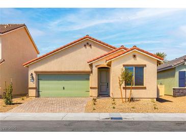 Charming single-story home featuring a green garage door, low maintenance landscaping, and a brick driveway at 3232 Lahontan St, North Las Vegas, NV 89032