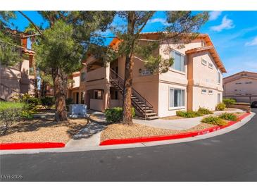 Low angle view of apartment building exterior with stairs and desert landscaping in front and visible parking restrictions at 350 S Durango Dr # 108, Las Vegas, NV 89145