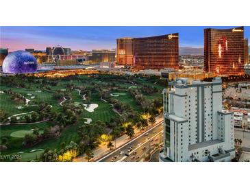 Striking aerial view showcasing the Las Vegas skyline, golf course, and modern building architecture at dusk at 360 E Desert Inn Rd # 1901, Las Vegas, NV 89109