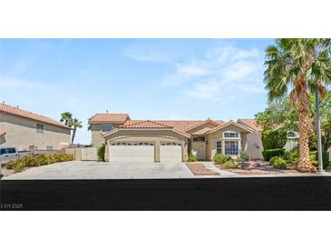 Charming two-story home featuring a three-car garage, desert landscaping, and a classic tile roof at 7736 Foredawn Dr, Las Vegas, NV 89123