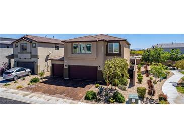 Beautiful home with a two-car garage and a lush landscaped front yard. Paved driveway at 7824 Warm Winds St, North Las Vegas, NV 89084