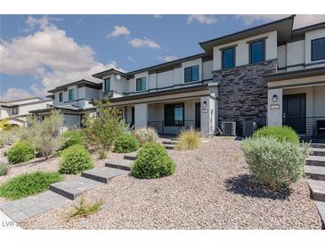 Modern townhome with stone accents, desert landscaping, and a paved walkway leading to the front door at 835 Jigglypuff Pl, Henderson, NV 89011