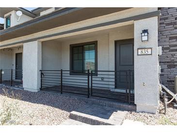 Inviting front porch with stone accents and a secure metal railing leading to the entrance at 835 Jigglypuff Pl, Henderson, NV 89011