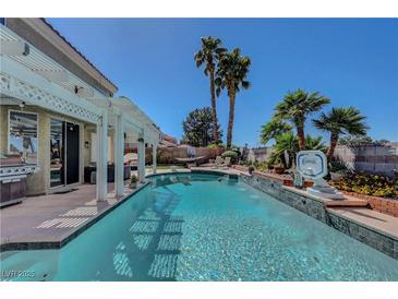 Inviting backyard pool with covered patio and mature landscaping, perfect for outdoor relaxation and entertainment at 2016 Catalina Marie Ave, Henderson, NV 89074