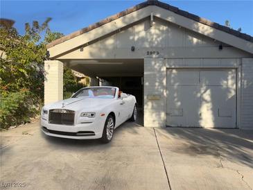 Exterior of a charming home featuring a carport, garage, and a luxurious white convertible at 2989 Bel Air Dr, Las Vegas, NV 89109