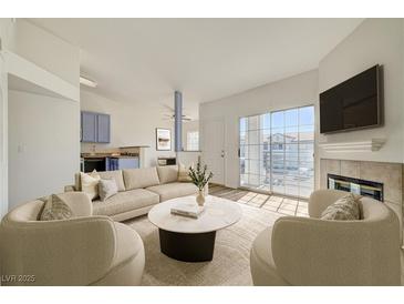 Bright living room with fireplace, large sliding doors, and tan sectional sofa and chairs at 3318 N Decatur Blvd # 2129, Las Vegas, NV 89130