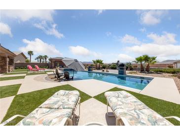 Inviting backyard oasis with a sparkling pool, lounge chairs, and lush landscaping at 3955 W Jo Rae Ave, Las Vegas, NV 89141