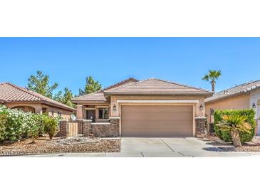 Charming single-story home featuring a two-car garage, desert landscaping, and a gated front porch at 5960 Wheat Penny Ave, Las Vegas, NV 89122