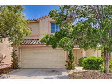 Charming two-story home featuring a two-car garage, lush landscaping, and a tiled roof in a desirable neighborhood at 7924 Horn Tail Ct, Las Vegas, NV 89131