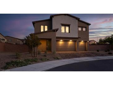 Charming two-story home featuring a three-car garage and desert landscaping at dusk at 1297 Ventura Cliffs Ave, Henderson, NV 89012