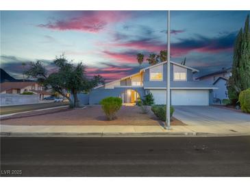 Charming two-story home with a two-car garage and desert landscaping at dusk at 1808 Piccolo Way, Las Vegas, NV 89146