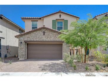 Charming two-story home with a two-car garage, stone accents, and desert landscaping at 387 Larksong Ave, Henderson, NV 89011