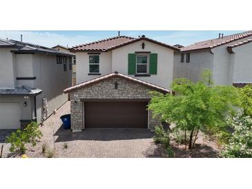 Charming two-story home with a stone-accented garage and terracotta roof tiles at 387 Larksong Ave, Henderson, NV 89011