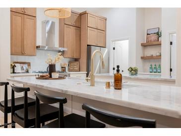Bright kitchen featuring wood cabinets, stainless appliances, and a stylish marble countertop at 4065 Genoa Dr, Las Vegas, NV 89141