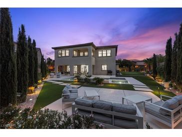 A luxurious backyard featuring a modern pool, patio furniture, and lush landscaping, perfect for outdoor entertaining at 4220 San Alivia Ct, Las Vegas, NV 89141