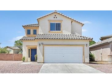 Two-story home featuring a two-car garage, blue door, tile roof, and neutral stucco facade at 4583 Sparwood Dr, Las Vegas, NV 89147