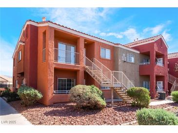Exterior view of a two-story condo building with desert landscaping and stairs to upper units at 4730 E Craig Rd # 1115, Las Vegas, NV 89115