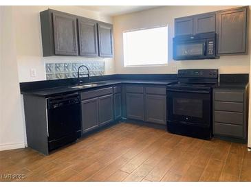 This is a kitchen with black appliances, grey cabinets, and tile flooring at 4910 Elizabeth St, Pahrump, NV 89048