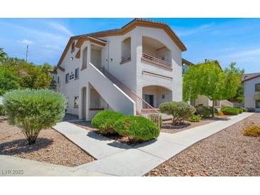 Inviting two-story condo featuring a private balcony, manicured landscaping, and stucco exterior at 5655 E Sahara Ave # 2009, Las Vegas, NV 89142