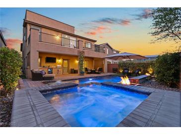 Beautiful backyard with a sparkling pool, spa, fire pit and covered patio for outdoor entertaining at 7322 Columbia Rock Ct, Las Vegas, NV 89178