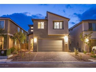 Two-story home with brick driveway and neutral stucco exterior, complete with a two-car garage at 8021 Adelaide Hills St, Las Vegas, NV 89113