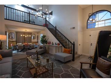 Bright, open living room with high ceilings, staircase, and contemporary furnishings for a welcoming ambiance at 9013 Cypress Point Way, Las Vegas, NV 89117