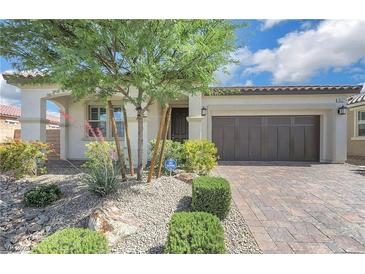 Charming single-story home featuring a well-manicured front yard and a brick driveway leading to a two-car garage at 10127 Knotty Skye Ave, Las Vegas, NV 89166