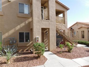 Tan two-story condo building with front entry, landscape and stairs to the second level at 2110 Los Feliz St # 1083, Las Vegas, NV 89156
