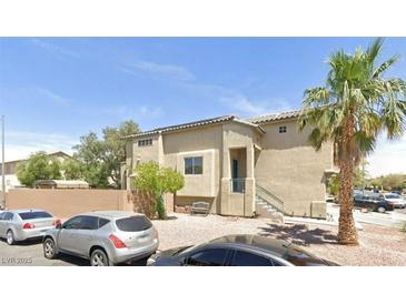 Beige two-story home with a tile roof, gravel landscaping, and a mature palm tree in the front yard at 3591 Gloucester Gate St, Las Vegas, NV 89122
