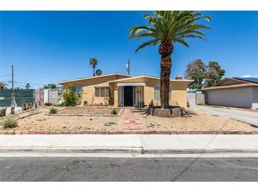 Charming single-story home featuring desert landscaping, a front yard palm tree, and a covered front porch at 513 Berry Cir, Las Vegas, NV 89107
