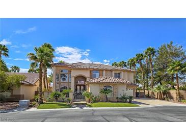 Elegant two-story home featuring a tiled roof, desert landscaping, and a secure gated entrance at 5445 Pendini Point Ct, Las Vegas, NV 89141