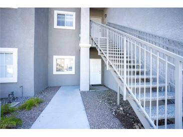 Modern condo exterior with gray stucco, white trim, and staircase leading to upper units at 6160 Rumrill St # 121, Las Vegas, NV 89113