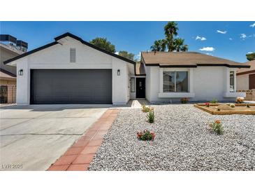 Charming single-story home with a well-maintained, low-water landscaped front yard and two-car garage at 6939 Paddington Way, Las Vegas, NV 89147