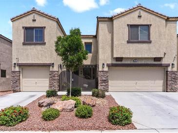 Charming townhome featuring desert landscaping, stone accents, and private gated entry, located in a desirable neighborhood at 1604 Patrick Thomas Ct, North Las Vegas, NV 89086