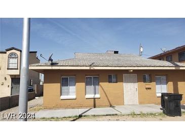 Single-story home featuring a brick facade, windows, and a security door, presenting a simple design at 2417 St George St, North Las Vegas, NV 89030