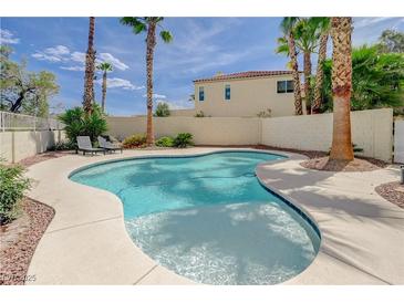 Inviting backyard pool with sunbathing deck and desert landscaping, surrounded by privacy walls and mature trees at 4 Tarryall Ter, Henderson, NV 89074