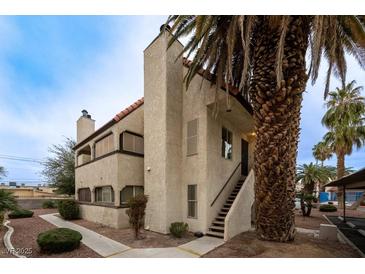 Charming multi-level building featuring stucco walls, a tile roof, and a mature palm tree in a desert landscape at 5040 Spencer St # D, Las Vegas, NV 89119