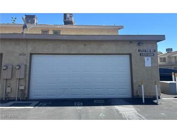 Exterior shot of attached garage at 6420 Little Pine Way, featuring a white door and neutral facade at 6420 Little Pine Way, Las Vegas, NV 89108