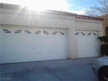 Attached two-car garage featuring white doors with decorative windows, providing convenient parking and storage at 8847 W Katie Ave, Las Vegas, NV 89147
