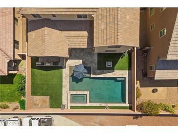 Aerial view of backyard featuring a pool, spa, patio, artificial turf, and fire pit at 8953 Hitch Creek St, Las Vegas, NV 89131