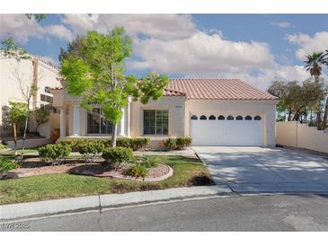 Charming single-story home with a tile roof, manicured lawn, and attached two-car garage at 9404 Calico Garden Ave, Las Vegas, NV 89134