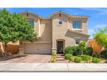 Charming two-story home with a well-manicured lawn, neutral stucco, and brick paver driveway at 9654 Ponderosa Skye Ct, Las Vegas, NV 89166