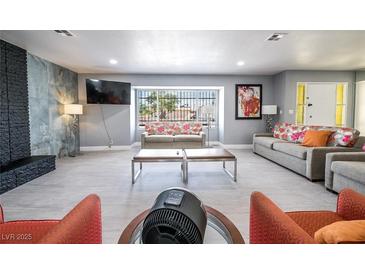 Spacious living room featuring modern gray walls, tile flooring, and large windows, creating an inviting space at 1521 Sombrero Dr, Las Vegas, NV 89169