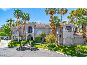 Stunning gray two-story home boasting manicured lawns and palm trees at 1931 Pago Ct, Las Vegas, NV 89117