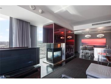 Modern living room features a fireplace and city views, plus an integrated bar and seating area at 4381 W Flamingo Rd # 2122, Las Vegas, NV 89103