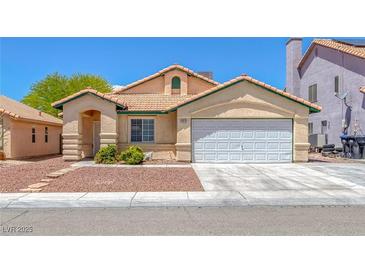 Inviting single-story home with a charming tiled roof, two-car garage, and desert landscaping in a vibrant community at 4619 Reliant St, North Las Vegas, NV 89031
