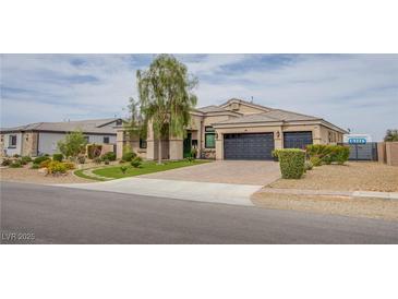 Beautiful single-story home with a three-car garage, manicured landscaping, and brick-paved driveway at 6060 N Conquistador St, Las Vegas, NV 89149