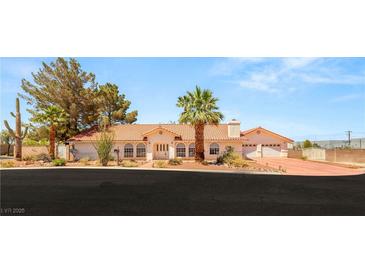 Charming single-story home showcasing desert landscaping, a terracotta roof, and a three-car garage at 7110 La Cienega St, Las Vegas, NV 89119