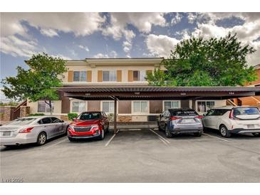 Exterior view of the complex with covered parking spaces and multiple cars parked underneath at 9303 Gilcrease Ave # 2198, Las Vegas, NV 89149