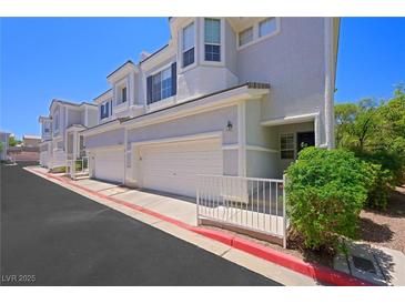 Inviting townhome featuring a two-car garage and lovely architectural details on a bright, sunny day at 245 Homesteader Ct, Henderson, NV 89052